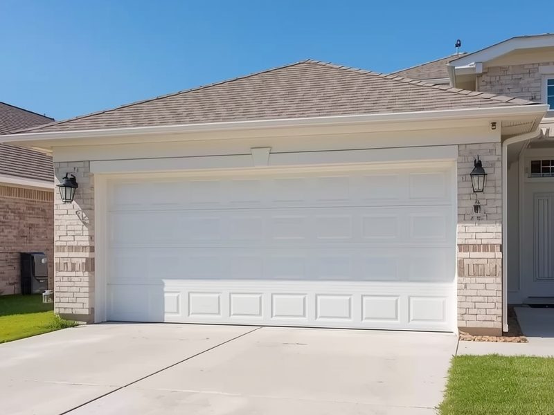 New white garage door installed on a Houston Texas suburban home